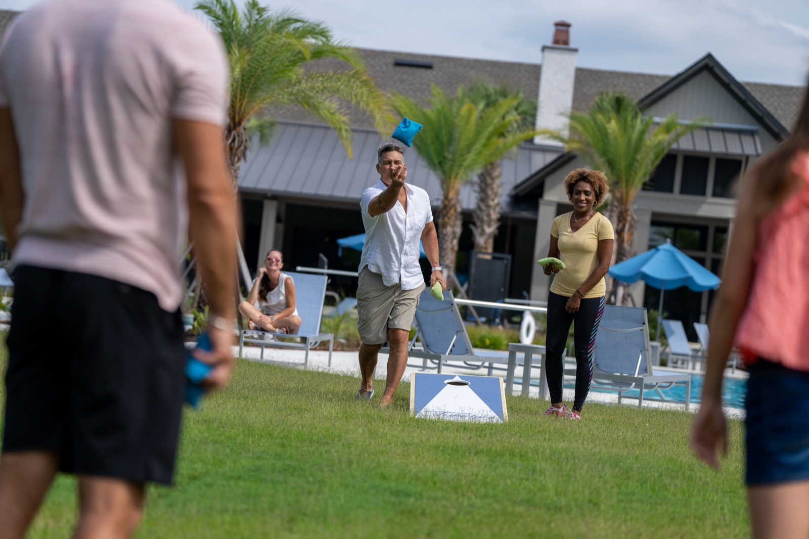 Friends playing cornhole at a Tributary park