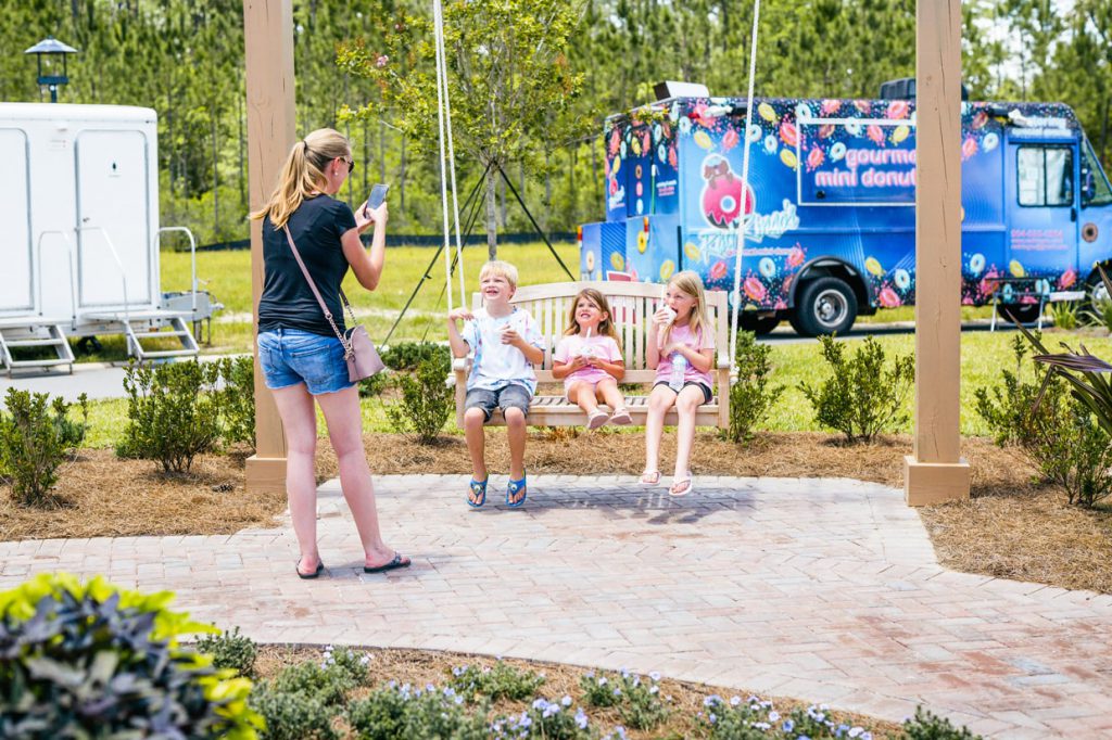 3 kids smiling eating ice cream at Tributary Model Home Event