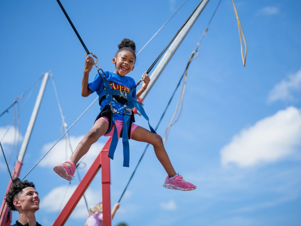 girl smiling on sling shot at Tributary Model Home Event