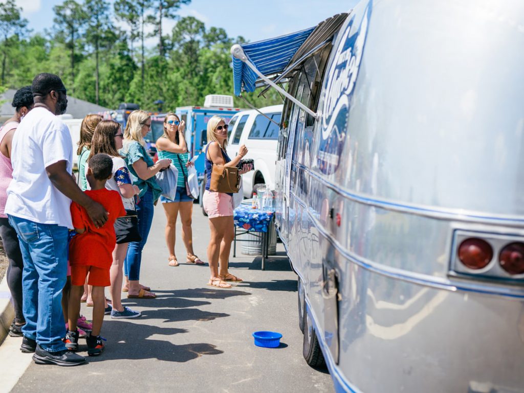 people lined up at food truck at Tributary Model Home Event