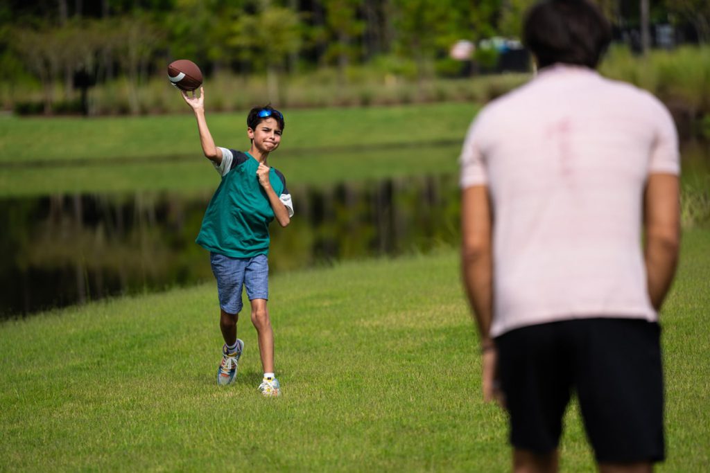 father and son playing football