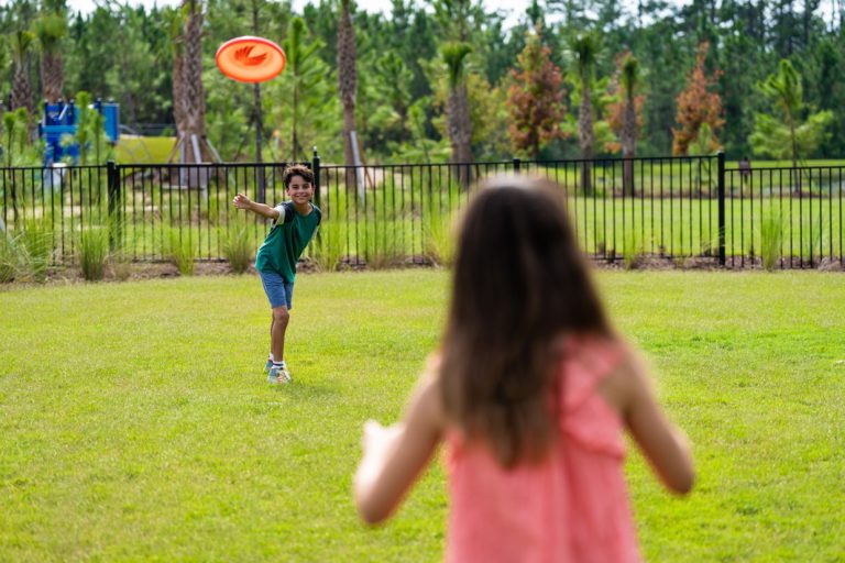 kids playing frisbee on the amenity center lawn