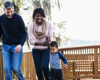 Family walking with two children on a wooden boardwalk.