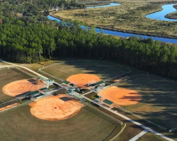 Aerial view of baseball fields near winding marsh river