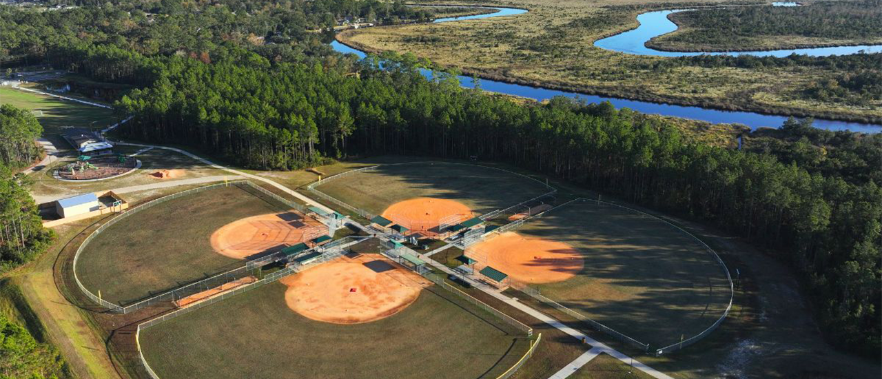 Aerial view of baseball fields near winding marsh river
