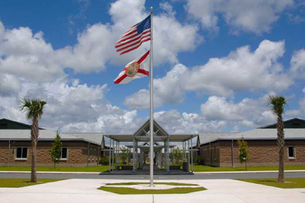 Brick school entrance with American and Florida flags on central flagpole